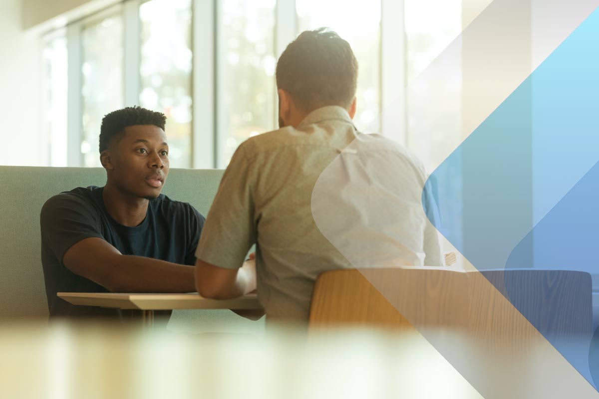 Stock image of two people talking to accompany article on active listening and mental health in the workplace