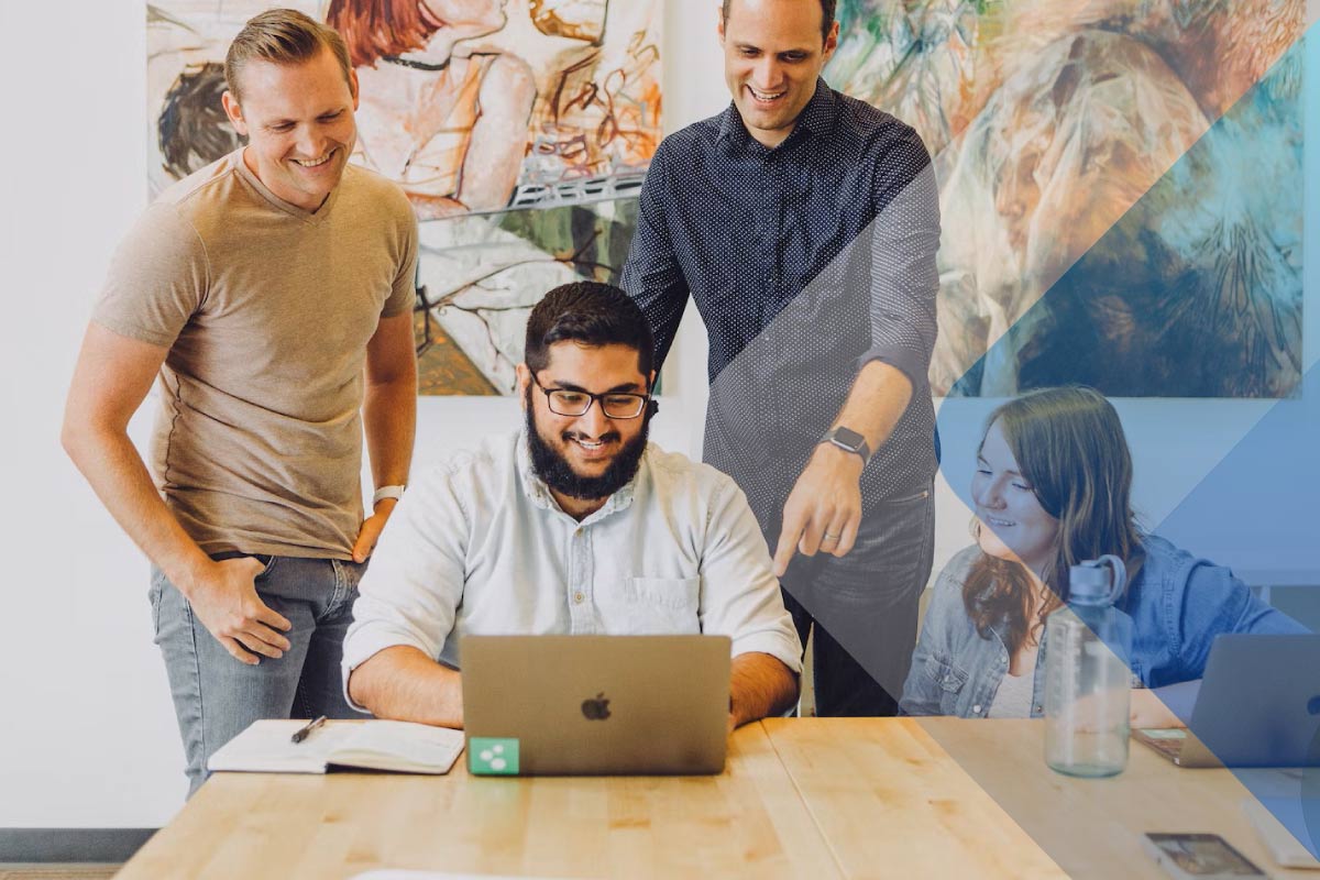 Stock image of professionals looking at a computer to accompany article on the employee life cycle.