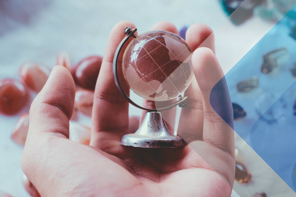 A stock photo of someone holding a mini globe to accompany article on setting up a successful global mobility program fernando-cferdophotography-tNDYN8jWyfM-unsplash
