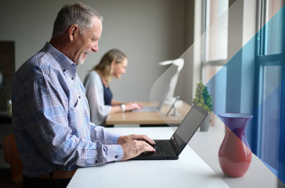 Stock image of older adult working on a computer to accompany article on hiring in Mexico