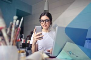 Woman checking phone to illustrate article on international recruitment and staff selection. Image by Bruce Mars on Unsplash.