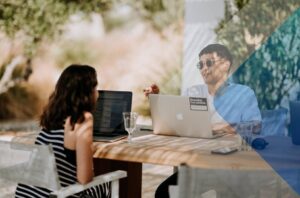 Two people at a table to illustrate how you would overcome communication challenges on a remote team. Photo by Unsplash on the site Unsplash