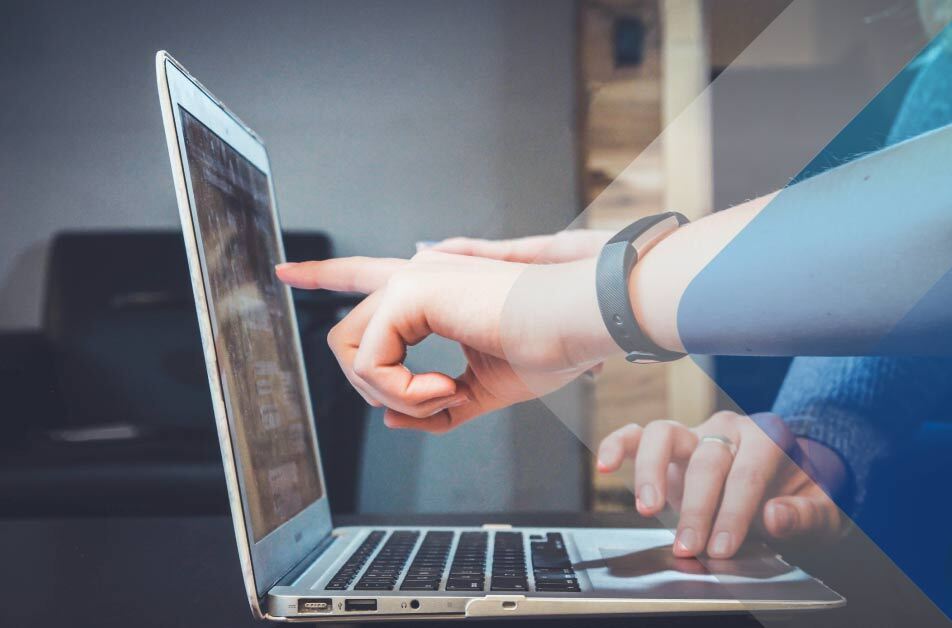 Person pointing at computer screen to illustrate article on global recruiting. By John Schnobrich on Unsplash