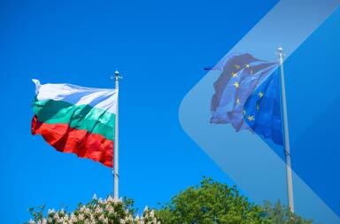Banderas de Bulgaria y la UE al viento por Neven Myst en Unsplash. Utilizado para ilustrar un artículo sobre el empleador de registro en Bulgaria.
