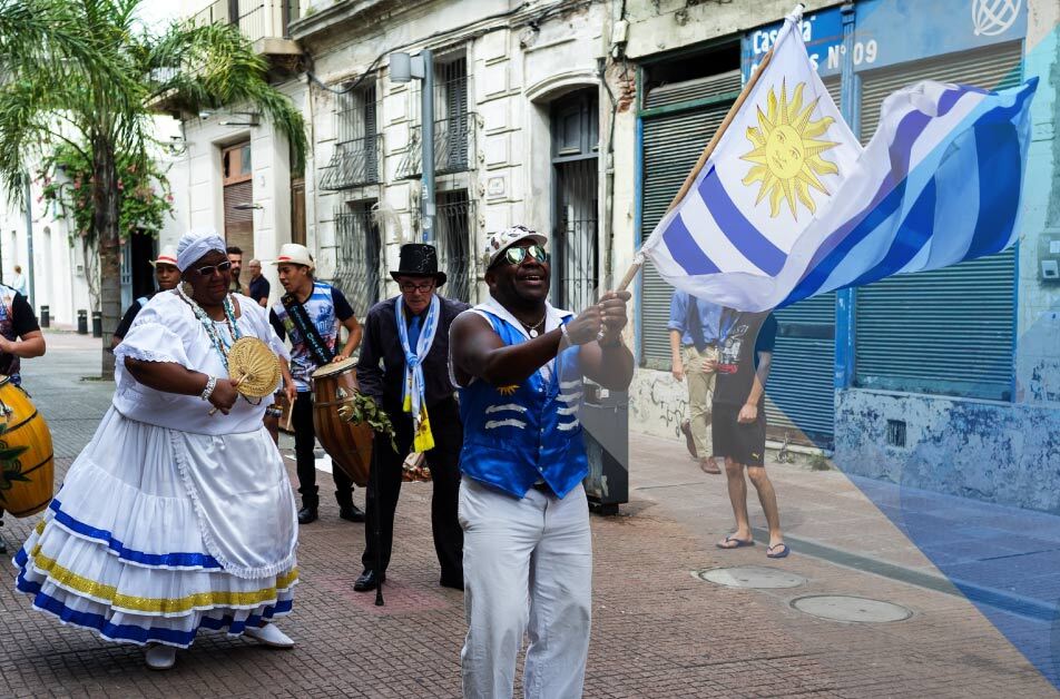 People waving flag in street to illustrate article on EOR in Uruguay. By Nigel SB Photography on Unsplash.