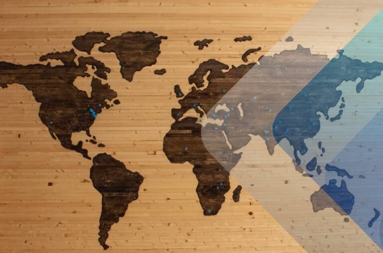 Map of the world in wood to illustrate article on hiring remote employees in other countries. By Brett Zeck on Unsplash.