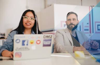 Workers at table on laptops to illustrate article on recruiting as a service. By Jason Goodman on Unsplash.