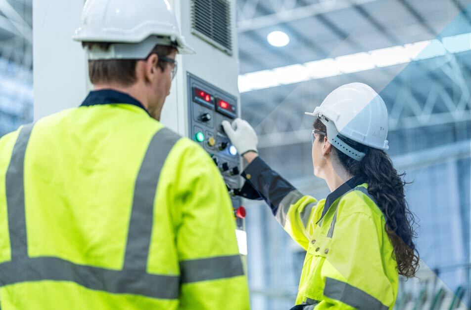Dos empleados trabajando en equipos para fábricas de montaje electrónico