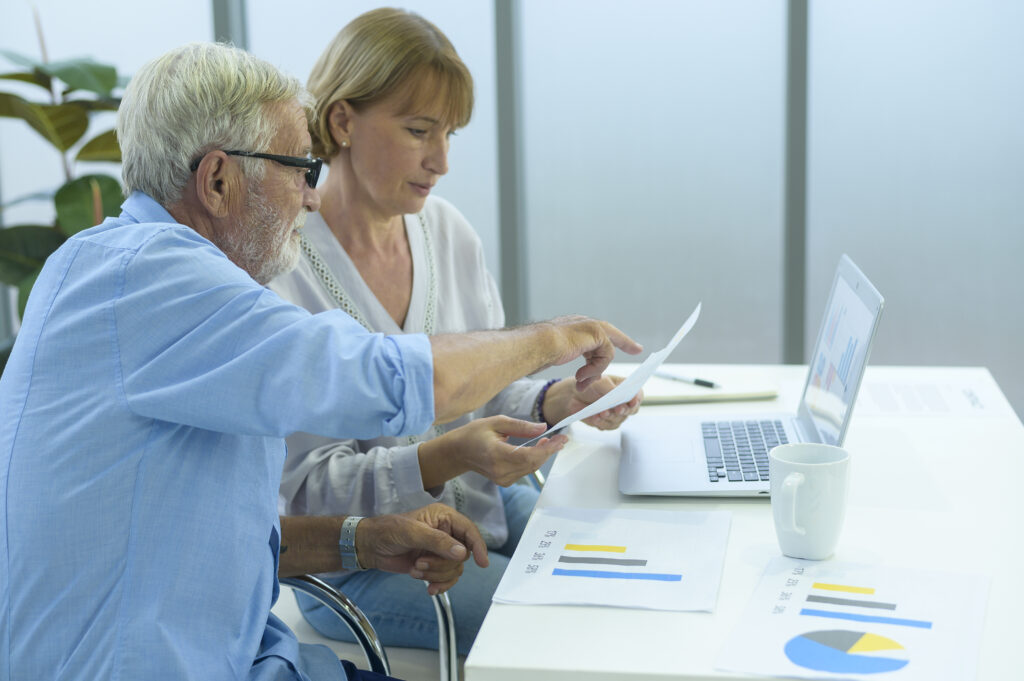 Empresarios caucásicos de alto nivel trabajando en una oficina moderna, elaborando planes de jubilación de empleados.