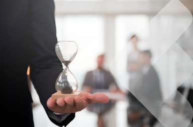 Un empresario sostiene un reloj de arena, que representa el cálculo de la jornada laboral en América Latina.