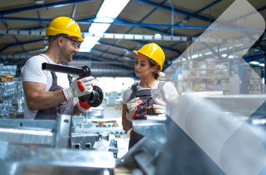 Dos personas trabajando en una planta de manufactura, una de las industrias clave en las tendencias en contratación global para 2025.