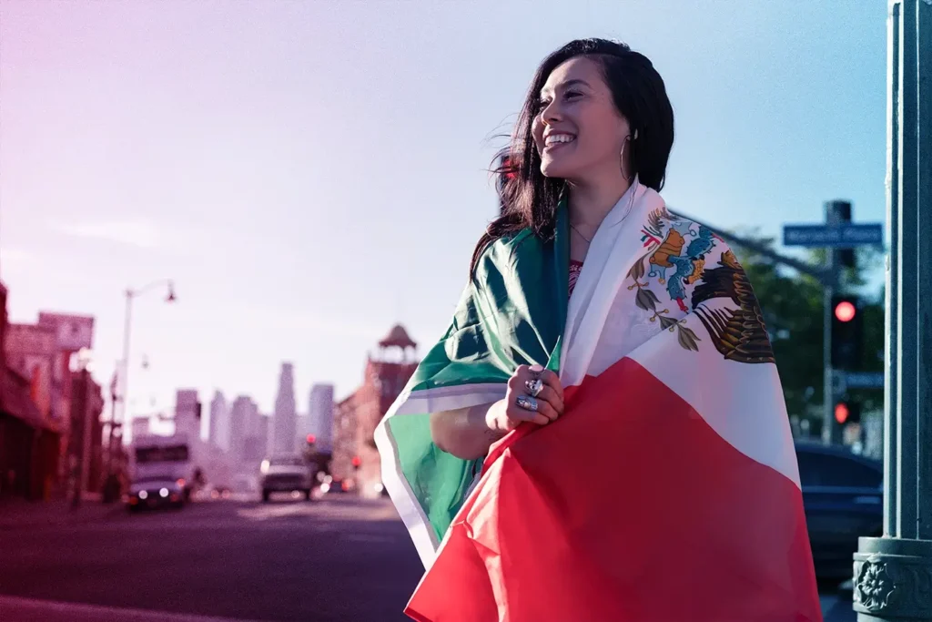 A woman holding the Mexican flag to illustrate the discussion of working hours in Mexico.